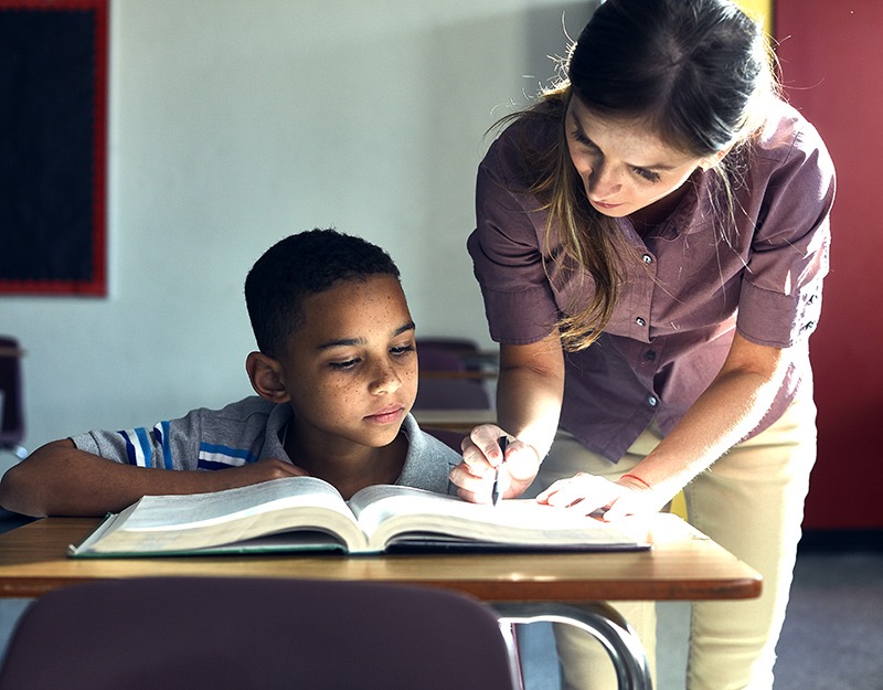 woman helping boy with his homework