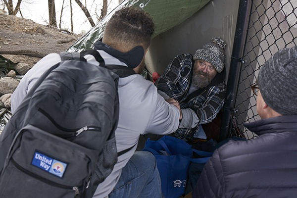 2 men helping out a homeless man